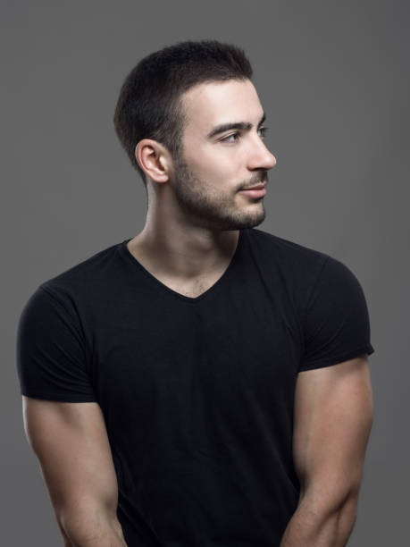 Happy confident fit man in blank black shirt looking away