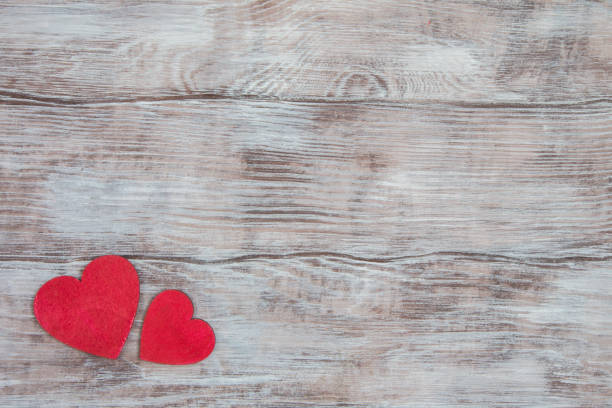 Light wood background and two small red hearts in corner