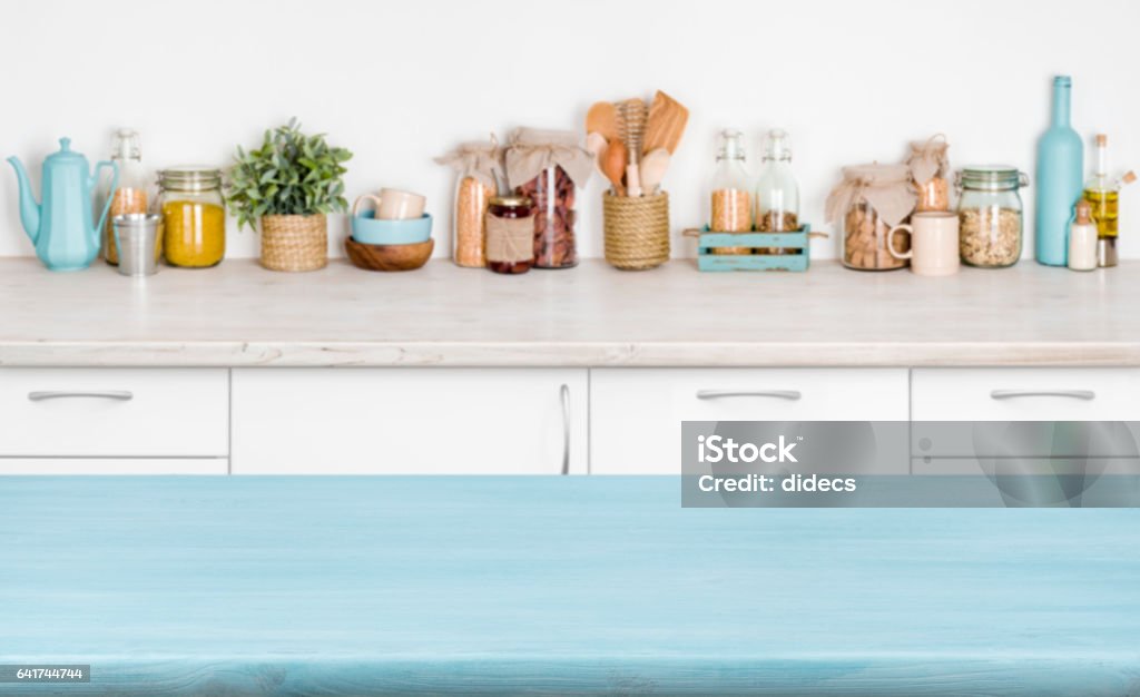 Blue empty wooden kitchen table over blurred food ingredients background Kitchen Stock Photo