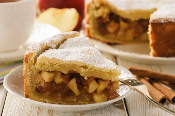 istock Apple pie and cup of tea on white wooden background. 641744772