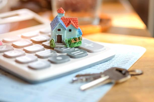 istock House model and key with calculator on book bank. 641746342