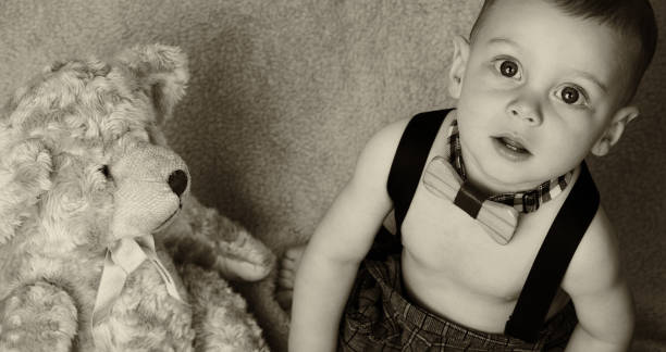 istock Baby boy sitting on soft blanket with a teddy bear 641749512
