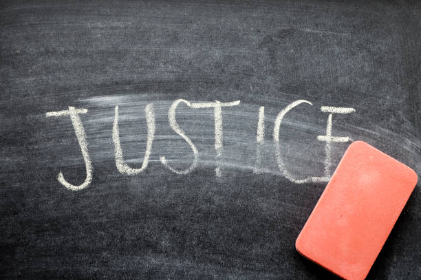 istock erasing justice, hand written word on blackboard being erased concept 641752302