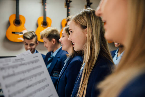 Music Lesson At School Close up shot of choir students singing in their music lesson at school. school choir stock pictures, royalty-free photos & images
