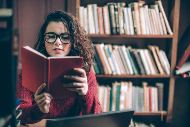 mulher jovem estudante - people reading book library - fotografias e filmes do acervo