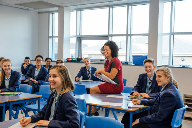 Happy High School Lesson Happy high school students and a teaching assistant are laughing at their teacher who is out of the frame, during a school lesson. respect photos stock pictures, royalty-free photos & images