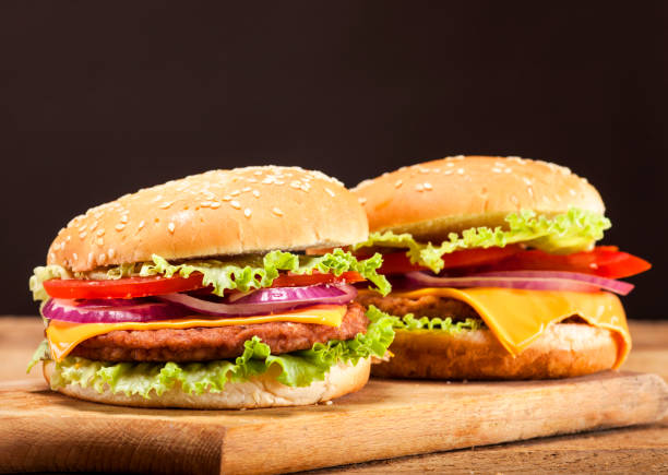 istock Fresh burgers on wooden background 641756234