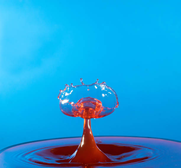 istock Collision of two drops on a surface of water 641764532