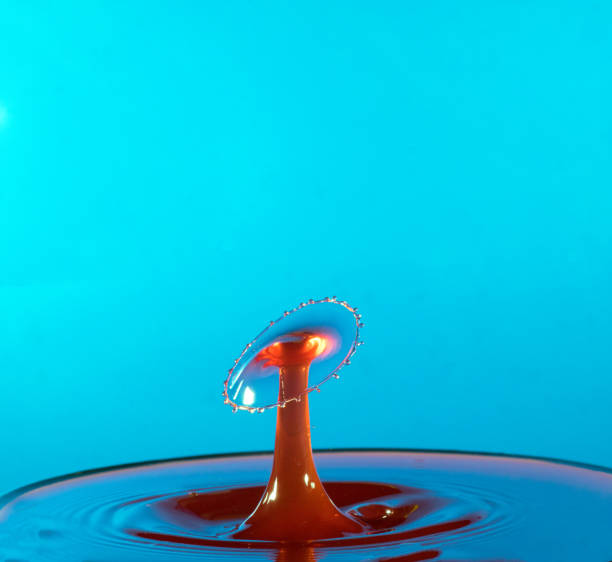 istock Collision of two drops on a surface of water 641764550