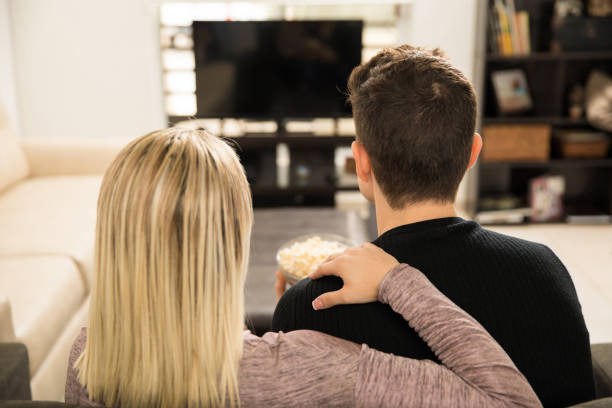 istock Young couple watching TV at home 641767782