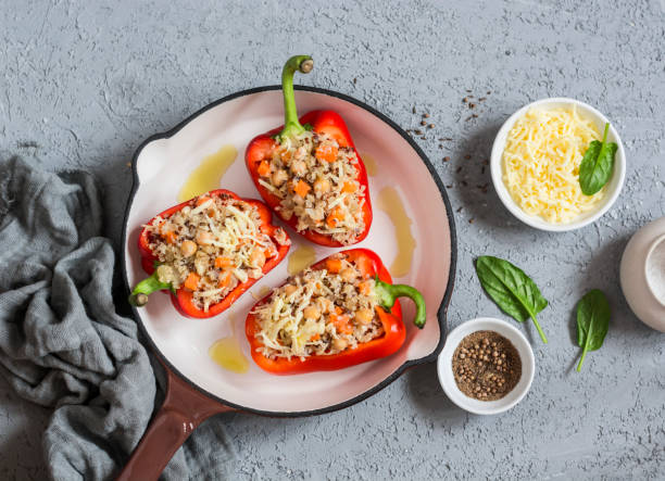 Raw quinoa stuffed sweet peppers in a cast iron skillet. Top view. Healthy, vegetarian food concept Raw quinoa stuffed sweet peppers in a cast iron skillet. Top view. Healthy, vegetarian food concept hungarian pepper stock pictures, royalty-free photos & images