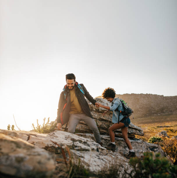 istock Young couple hiking help each other in mountains 641773498