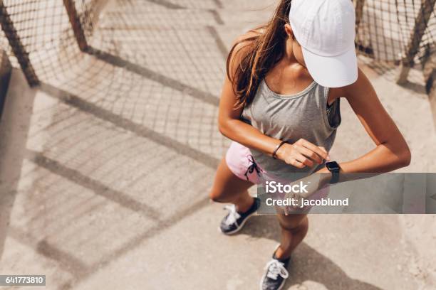 Female Runner Looking At Smart Watch Heart Rate Monitor Stock Photo - Download Image Now