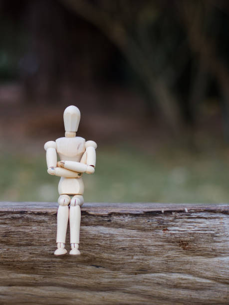istock Wooden Man - Lonely figure sitting alone 641774044