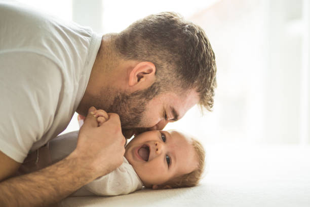 Happy father playing with his daughter Happy mature father playing with his baby daughter (3 months old). babyhood stock pictures, royalty-free photos & images