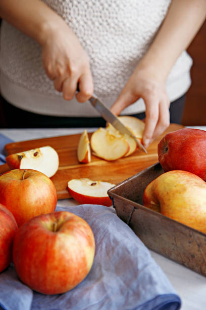 istock Woman cutting apples on a wooden board 641792706
