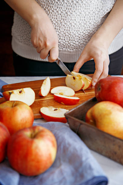 istock Woman cutting apples on a wooden board 641792708