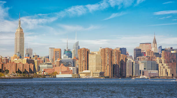 Manhattan skyline by East river against sky