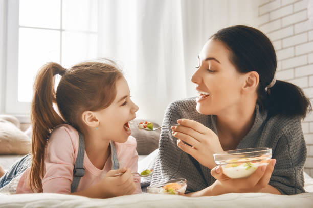 istock Mother and daughter eating salad 641796884