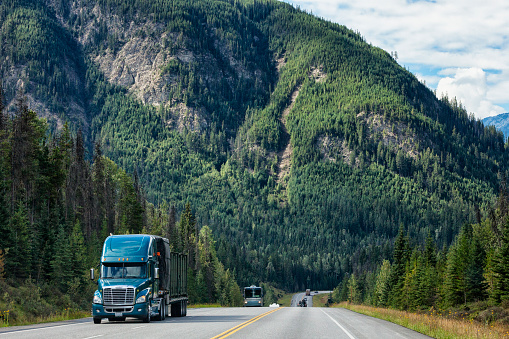 Semi-truck driving on the Trans-Canada Highway against the stunning landscape of southern British Columbia, Canada.