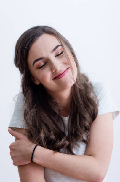 Girl in white t-shirt hugging herself