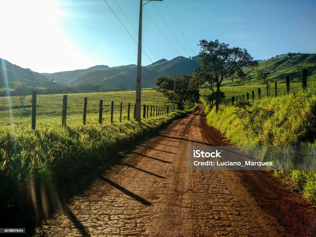 Dirt road Dirt road with sole blue sky amid the farms and green mountains Adventure Stock Photo