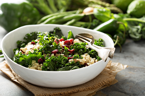 Healthy raw kale and quinoa salad with cranberry and almonds