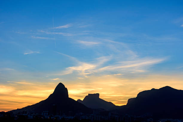 Dusk in Two Brothers hill and Gavea Stone Image of the late afternoon at Lagoa Rodrigo de Freitas in Rio de Janeiro with its mountains, buildings and characteristic outline two brothers mountain stock pictures, royalty-free photos & images