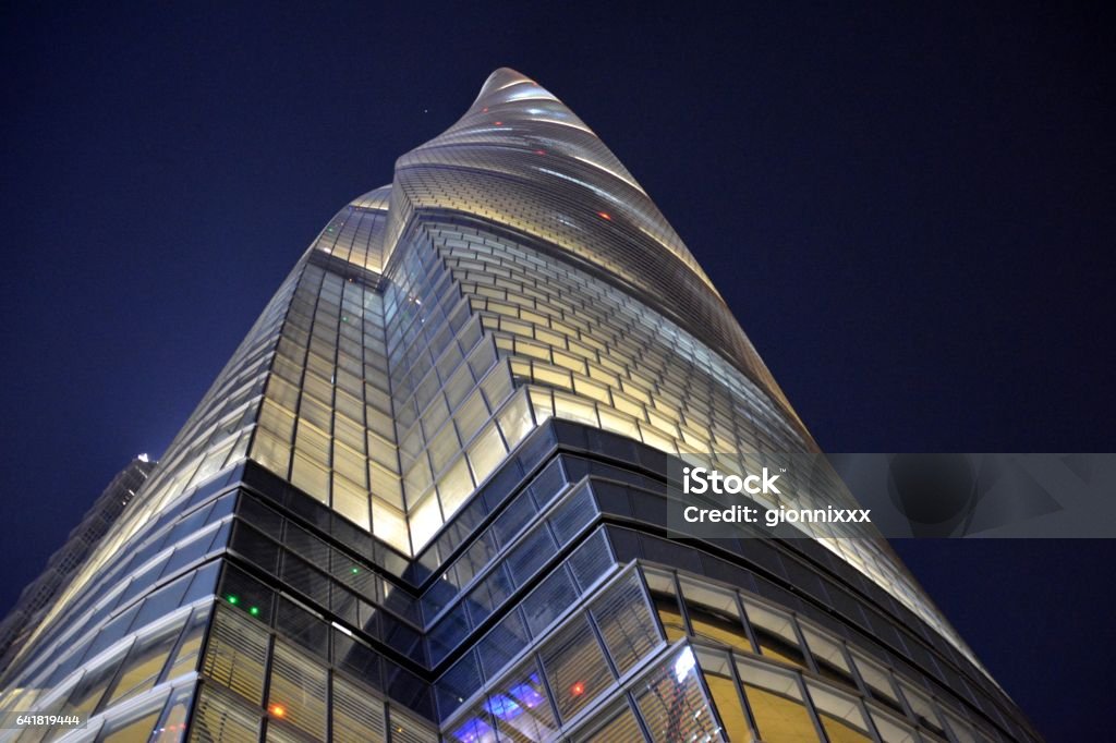 Shanghai Tower by night, Lujiazui, Shanghai, China directly below view of the awesome megatall skyscraper, the second tallest building in the world, height 632 mt, in Lujiazui finance and trade zone, Pudong district. Architectural Feature Stock Photo