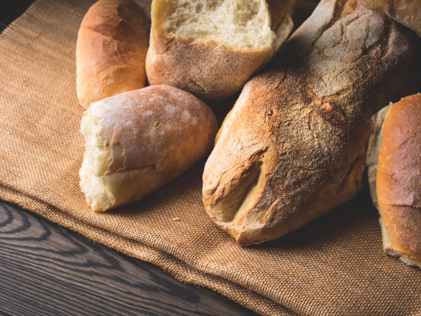 istock Freshly baked bread on burlap dark wooden background 641831360
