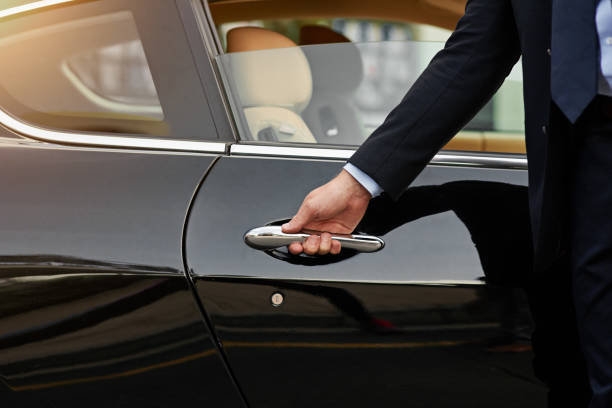 Your ride is here... Cropped shot of an unrecognizable male chauffeur opening a car door upper class stock pictures, royalty-free photos & images