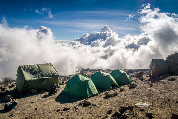 tende sopra le nuvole per le persone che trekking sul monte kilimangiaro - sleeping volcano foto e immagini stock
