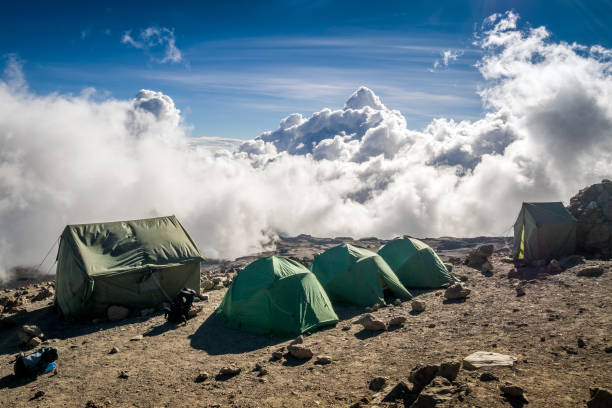 Dramatic view of tent camping on the top of the mountain with scenic view of mountain valley from above during very bright summer sunset time, Romsdal, Western Norway
