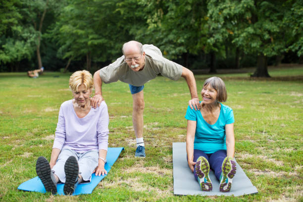 istock Senior man doing stretching workout with women at park 641834094