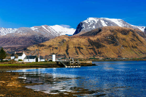 Ben Nevis mountain, Scotland Ben Nevis, Scotland's highest mountain, from Corpach. Some of the most world famous and iconic ice climbs are contained on its north face. The snow corniced summit can be glimpsed above the darker bulk of Carn Dearg. fort william stock pictures, royalty-free photos & images