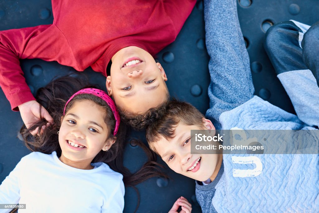 Childhood bliss Portrait of three young siblings playing together at the park Above Stock Photo