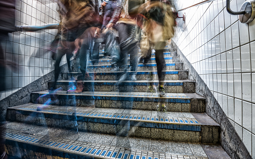 Motion blurred commuter in subway station stairs