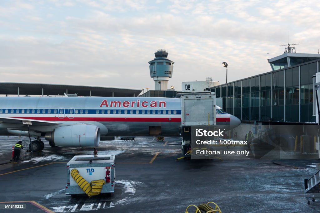American Airlines New York, USA - January 9th, 2016: The American Airlines jets parked late in the day at LaGuardia gate D8. Air Traffic Control Tower Stock Photo