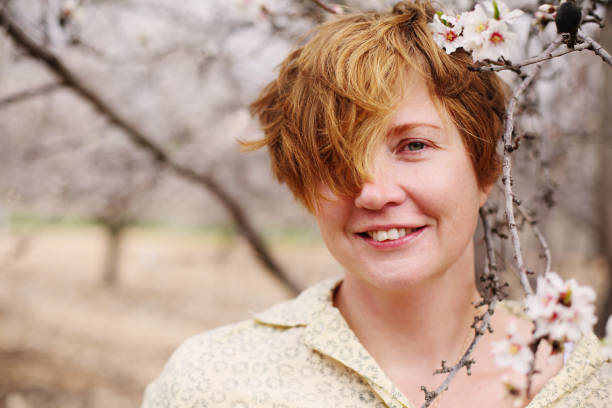 istock Happy standing woman in spring blossom park 641841532