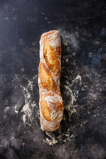 Fresh Baguette bread on dark background copy space