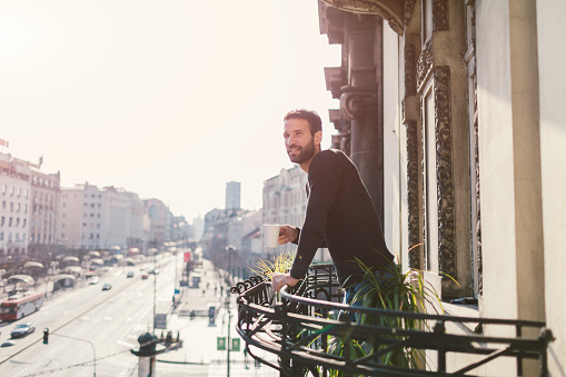 Single man drinking coffee on hotel balcony