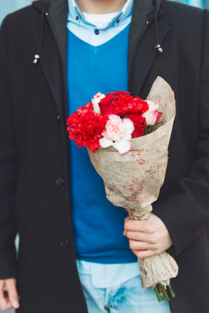 istock Man holding a flower bouquet, close up 641847058