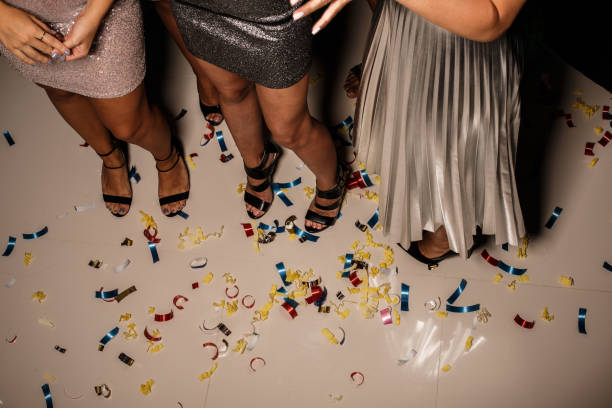 istock Women standing on confetti during party 641847162
