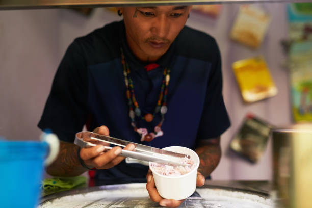 Shot of a food vendor preparing a sweet treat at a market stall