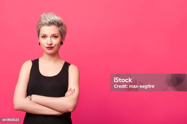 Confident Woman Standing With Arms Crossed Isolated Over Pink Background Stock Photo - Download Image Now