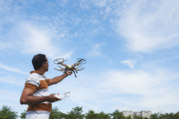 sonda de exploração homem com quatro rotores - drone subindo - fotografias e filmes do acervo
