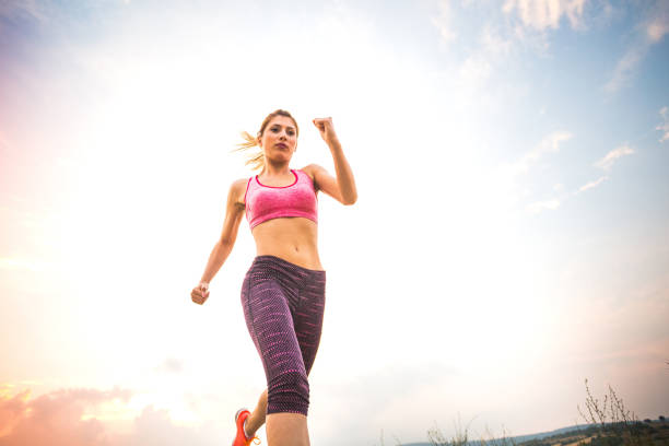 Beautiful woman at the moment of jump outdoors in sport clothes