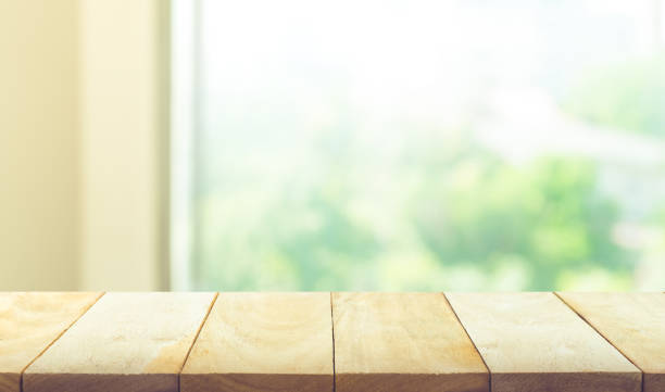 istock Wood table top on blur green garden from window view. 641863820