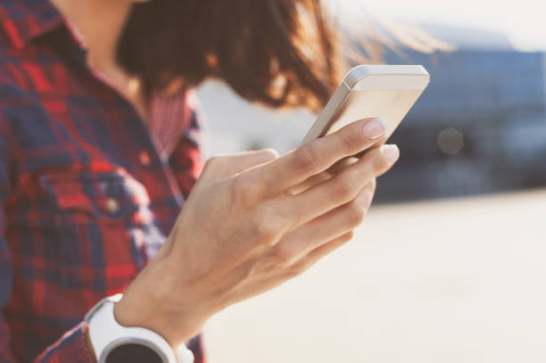 istock Young woman using smart phone outdoors 641865998