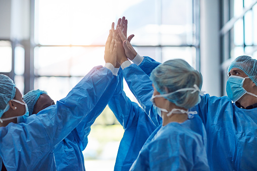 Cropped shot of a team of medical practitioners high fiving together in a hospital